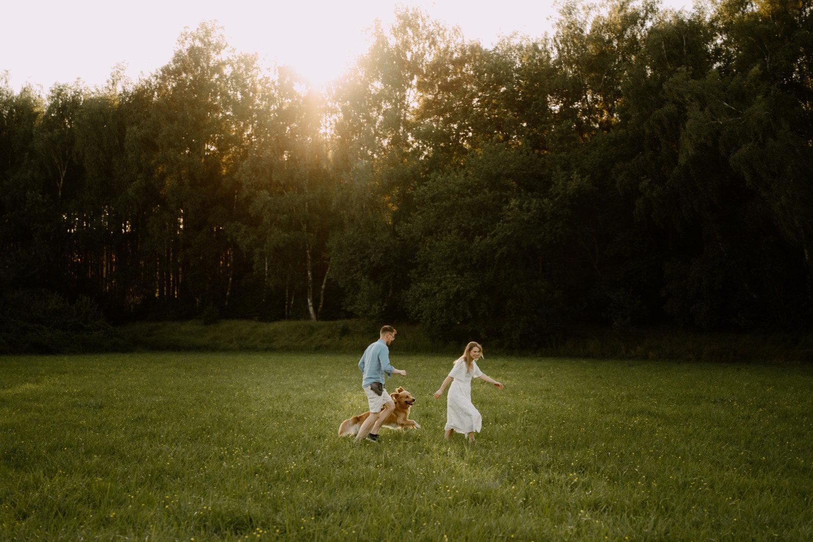 para biegnąca na łące z psem